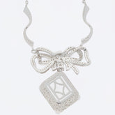 Elegant sterling silver necklace with a bow design and a decorative diamond-shaped pendant.